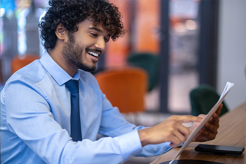 Young man sitting at a desk in an office reviewing job opprtunities in Manpower Group